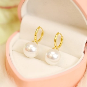 Close-up of elegant pearl drop earrings presented in a pink heart-shaped jewelry box