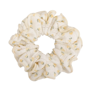 Detail of off-white floral scrunchie with lace texture and yellow flower pattern