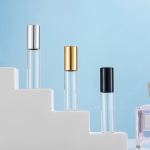 Set of three transparent glass perfume roller bottles with gold, silver and black metal caps