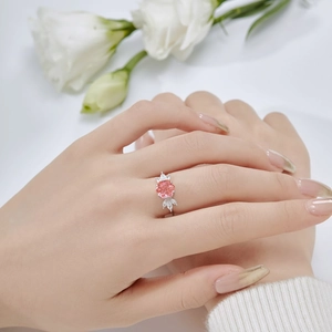 Close-up of a S925 silver ring featuring a pink flower-shaped gemstone on a finger