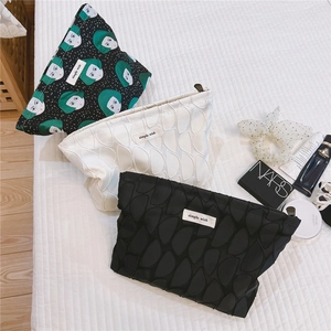Detailed view of fashionable canvas cosmetic bags with wave patterns and zipper closure