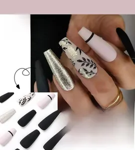 Detail of matte black and gold glitter coffin nails with hand-painted leaf patterns