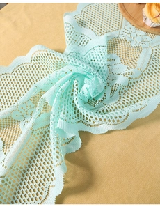 Close-up of mint green lace table runner with hollow mesh and wavy scalloped edges