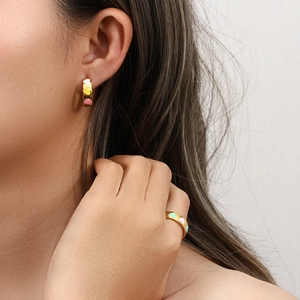 Detail of colorful enamel heart earrings and ring set on model for a trendy fashion look