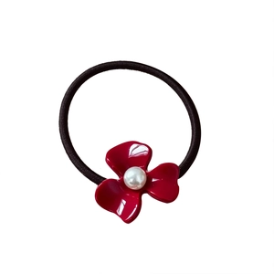 Elegant red acetate flower hair scrunchie with white pearl center on black elastic band