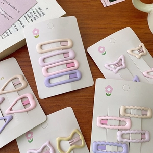 Süßes Haarklammern-Set in Pastellrosa und Lila auf Karte mit floralem Hintergrund
