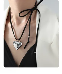 Detailed view of 3D silver heart pendant with black cord tie and silver bead accents