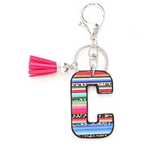 Detail of letter C keychain featuring vibrant Mexican stripes, leopard print and pink tassel
