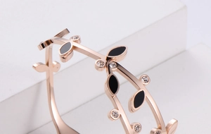 Detail of rose gold leaf bracelet with black dripping oil finish and sparkling crystals