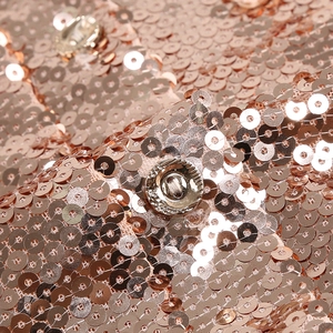 Macro shot of shimmering rose gold sequins and a textured vintage metal button
