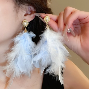 Detail of long drop earrings featuring light blue feathers and white faux pearl on model