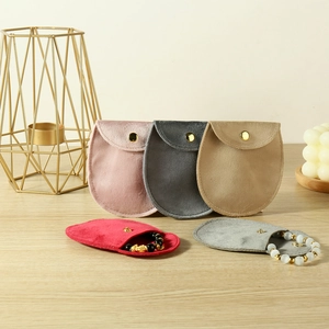 Velvet jewelry pouches in multiple colors featuring gold snap buttons and bracelets