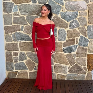 Detailed close-up of a red off-shoulder two-piece dress set with long sleeves and maxi skirt
