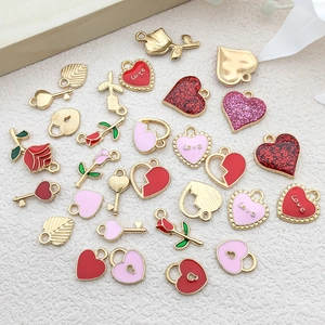 Flat lay of golden alloy heart and flower charms with Love engraving for DIY jewelry