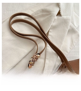 Gros plan d'un cabas en cuir marron avec surpiqûres blanches et foulard en soie