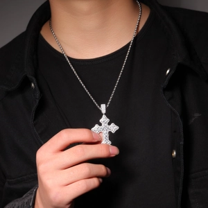 Gros plan d'un pendentif croix en zircon sur chaîne corde porté par un mannequin noir