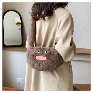 Detail of plush brown shoulder bag with quirky big eyes and pink lips monster design