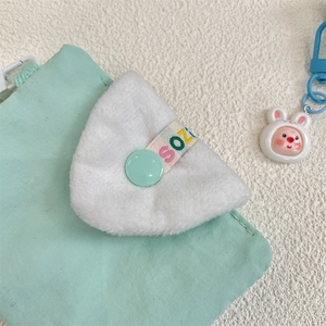 Detail of white faux fur coin purse with mint green snap button and rabbit keychain