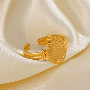 Polished gold irregular oval ring with micro-grid texture on silk background