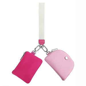 Dettaglio di pochette da polso in tessuto rosa e fucsia con moschettone d'argento