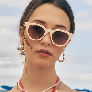 Cat eye sunglasses with beige frames and gradient brown lenses worn by model outdoors