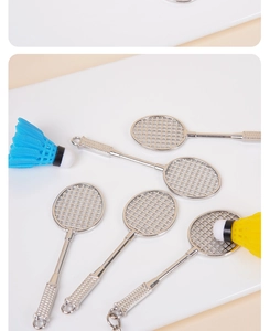 Dettaglio macro del portachiavi con racchetta da badminton e volano in metallo argento