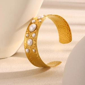 Detailed view of hammered 18K gold plated cuff bracelet with inlaid white pearls