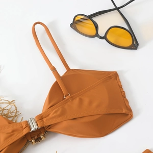 Detail of caramel bikini top featuring adjustable straps and gold metal clasp closure