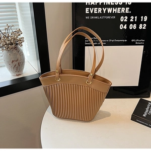 Close-up of pleated khaki faux leather tote bag with elegant gold metal ring hardware