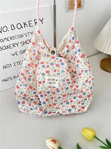 Detailed close-up of floral canvas tote bag featuring metal snap button and woven handles