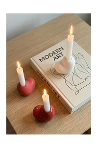 Close-up of modern heart ceramic candle holders in matte and glossy finishes on a table