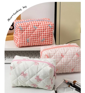 Three-piece quilted cotton makeup bag set in red and pink plaid with bow patterns
