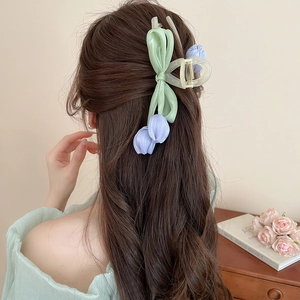 Detail of a light green bow and lavender tulip fabric flower on a frosted hair claw clip