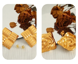 Details von quadratischen Gold-Ohrsteckern aus Titan mit horizontaler Textur und Silikonverschluss