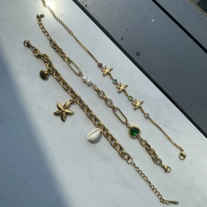 Detailed shot of gold starfish bracelets with pearls, shells and colored gemstones
