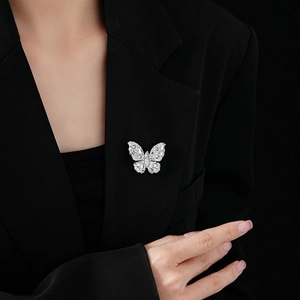 Detailed view of a silver zircon butterfly brooch pinned on a black suit lapel