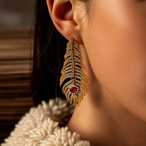 Macro view of vintage feather earrings with sparkling diamonds and a red gemstone center