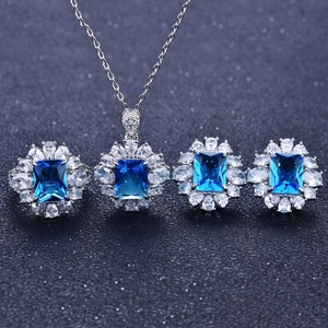 Elegant jewelry set featuring blue square gemstones with silver metal and halo design