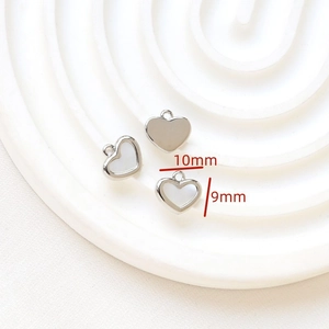 Macro detail of 10x9mm heart-shaped silver charms in solid and mother-of-pearl inlay