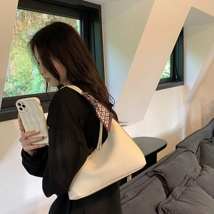 Chic cream white underarm bag with decorative scarf shown on a model's shoulder