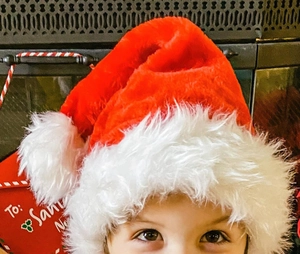 Close-up of a plush red and white Christmas hat featuring soft fur texture for children