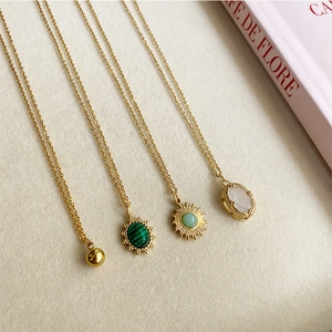 Détail de quatre colliers dorés de style français avec divers pendentifs en pierres précieuses