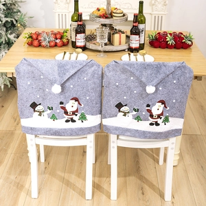 Detail view of grey Christmas chair covers with snowman patterns and white pom-poms