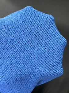 Vista macro della trama del maglione in maglia blu che mostra dettagli di tessitura