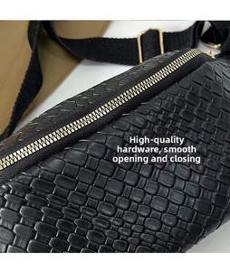 Gros plan sur un sac de poitrine noir tressé avec fermetures éclair en métal doré lisse