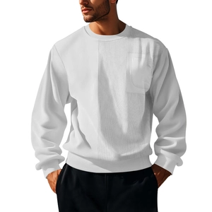 Detail of white crewneck sweatshirt showing corduroy patchwork and chest pocket texture
