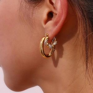 Close-up of 18K gold plated double hoop earrings featuring a pavé zircon twisted ring