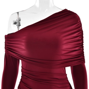 Détail de la robe moulante rouge foncé avec design plissé à l'épaule et à la taille