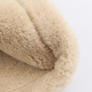 Macro shot of soft beige sherpa fleece texture on a reversible jacket detail