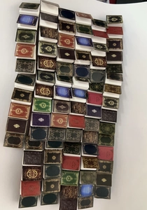 Macro shot of colorful miniature dollhouse books with vintage gold embossed patterns